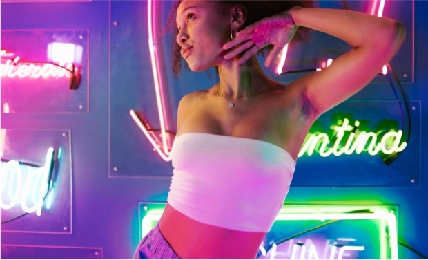 content creator posing in front of neon signs